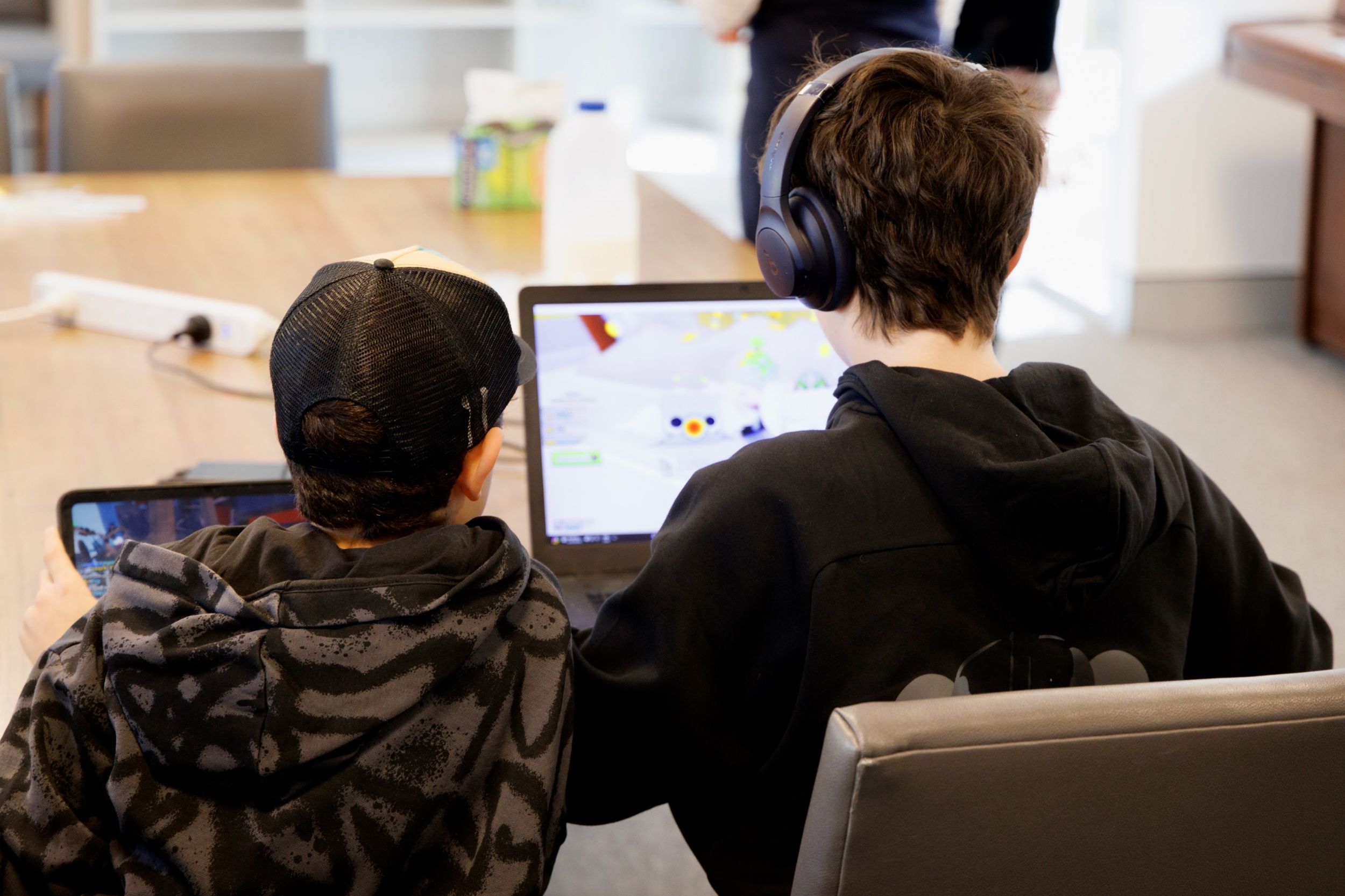  Image: Supplied by social enterprise FutureTech. Two young boys are sitting side by side, each using a laptop.