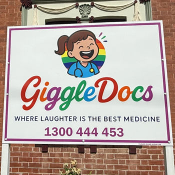 GiggleDocs sign reading "Where laughter is the best medicine," phone 1300 444 453, with a cartoon child in a rainbow logo.