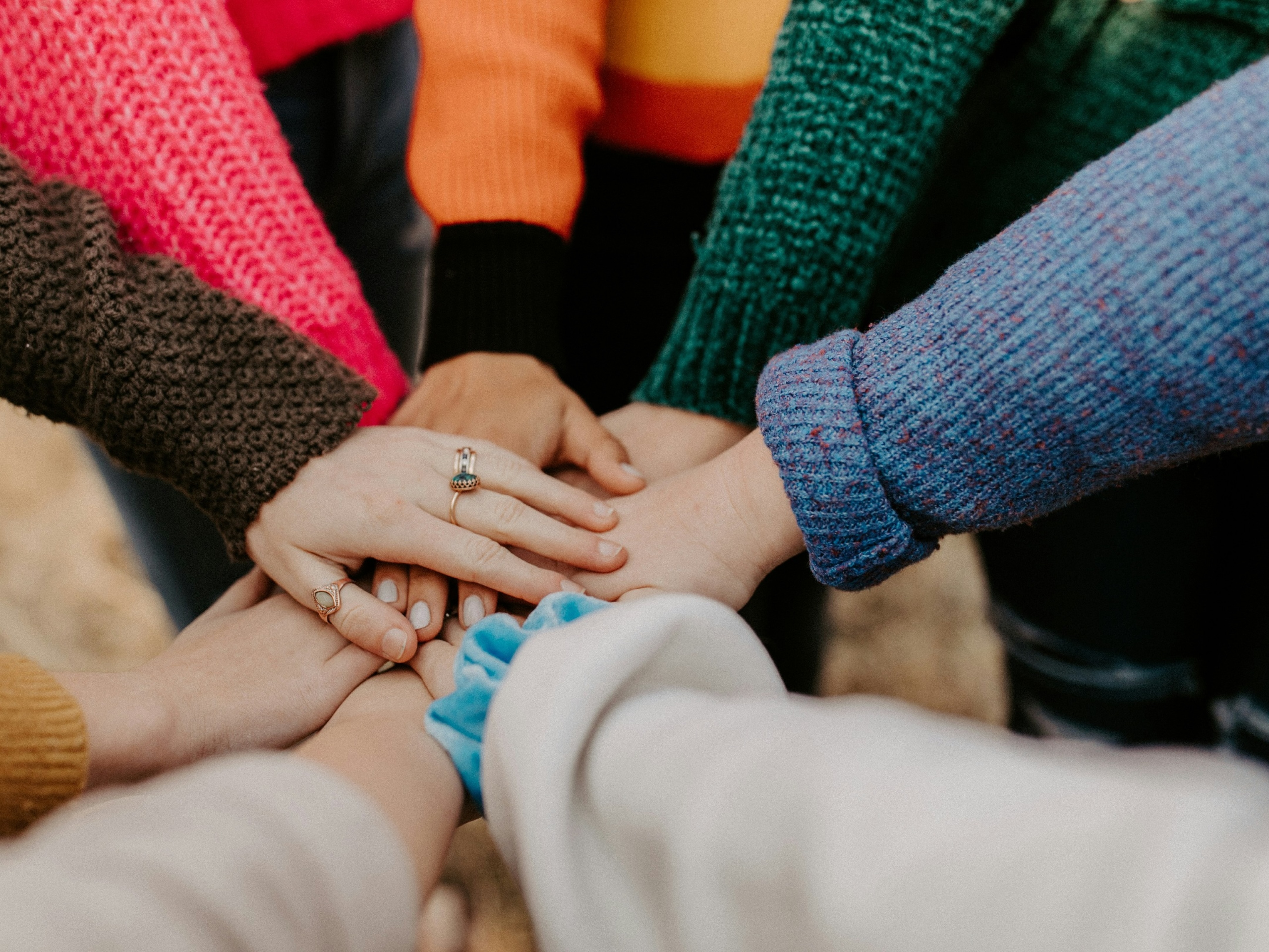 Team of people holding hands in a the middle of a circle